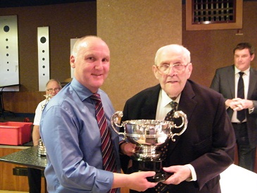 Jeffery Higgins receives the Logan Johnstone Cup  for the Malcolm Brodie Merit award from League President Herbie Johnstone.